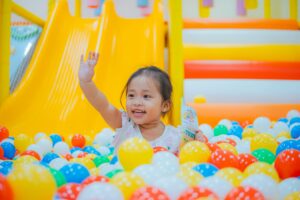 girl in ball pit having active indoor fun