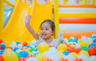 girl in ball pit having active indoor fun