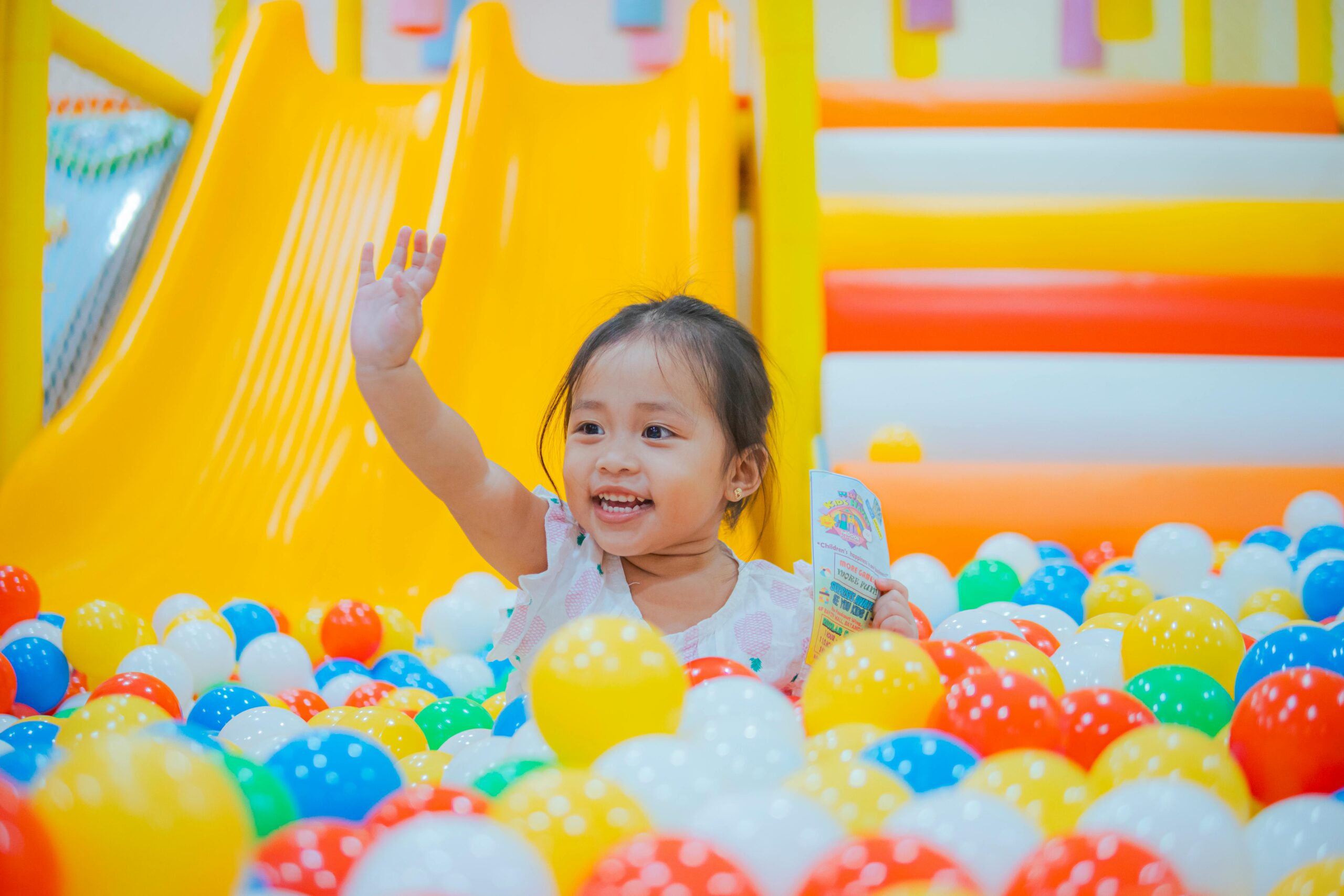 girl in ball pit having active indoor fun